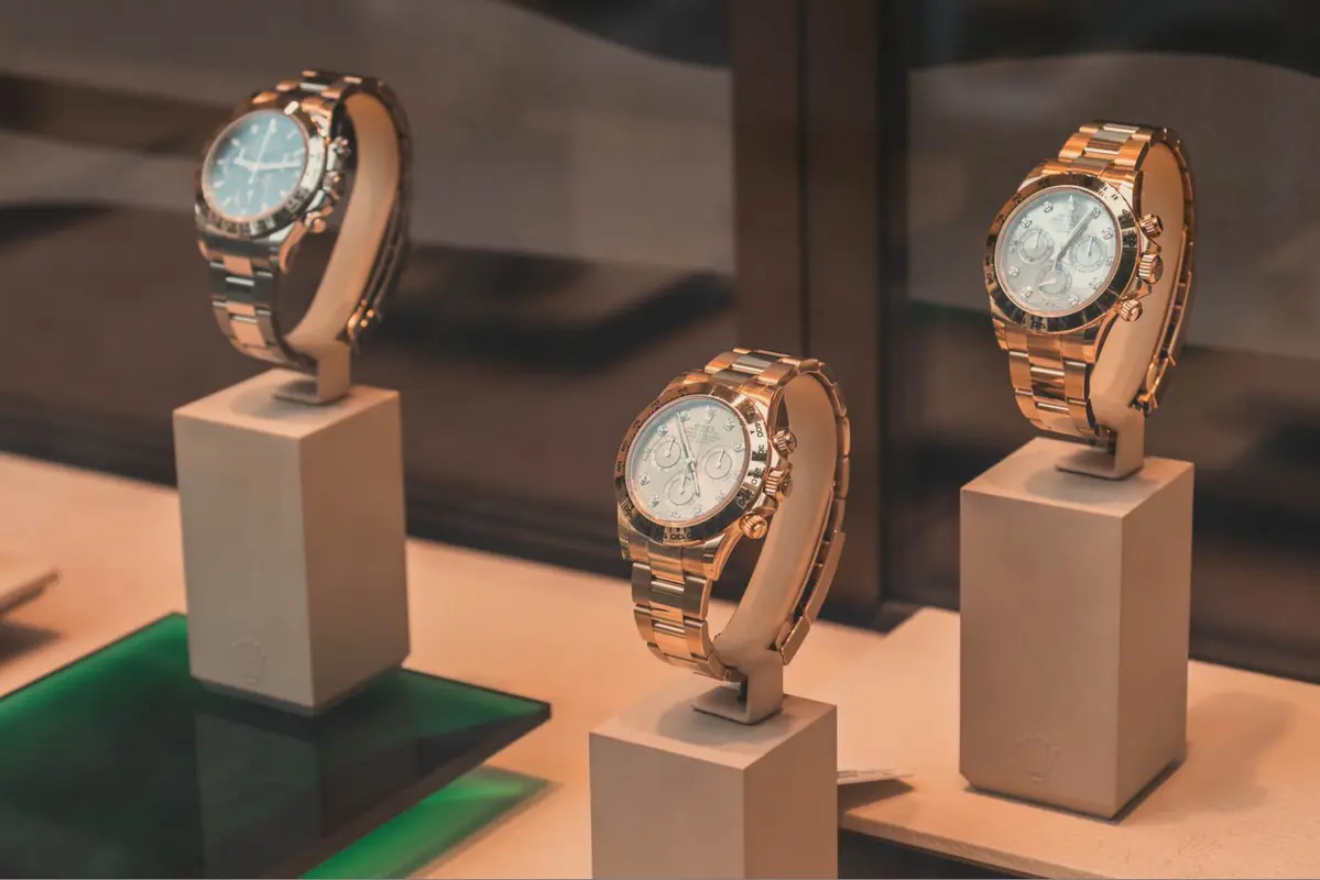 Three Rolex watches on display in a glass case