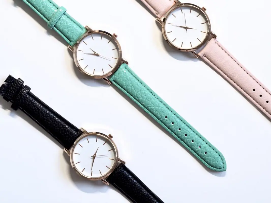 Coloured minimalist watches on a white surface